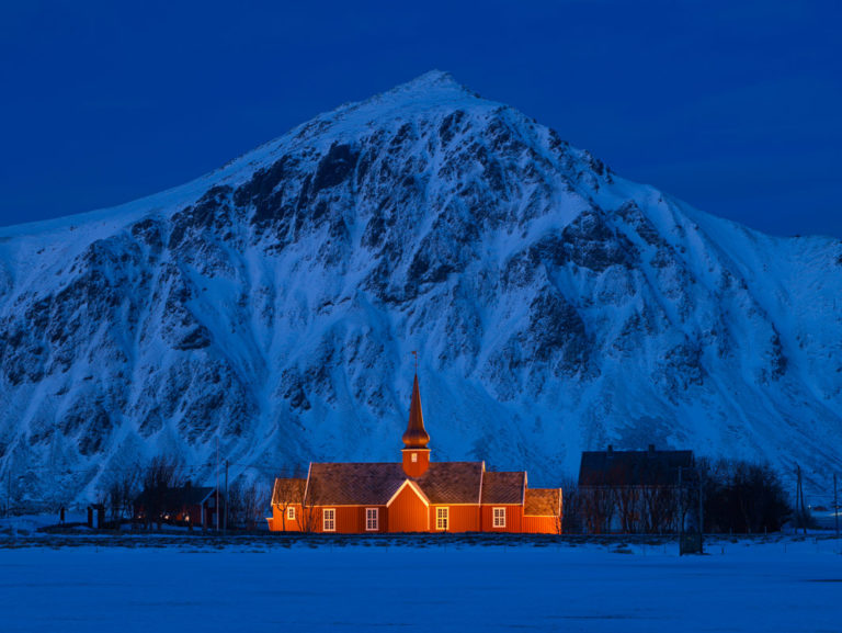 Kirke og fjell om kvelden. Mørketid i Nord-norge. Flakstad kirke på Flakstadøya. Flakstadøy. Vinter i Lofoten.